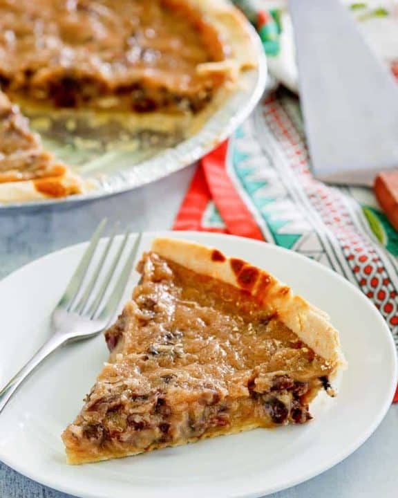 a slice of sour cream raisin pie on a plate next to the pie