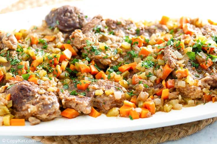 beef shanks with vegetables on a platter