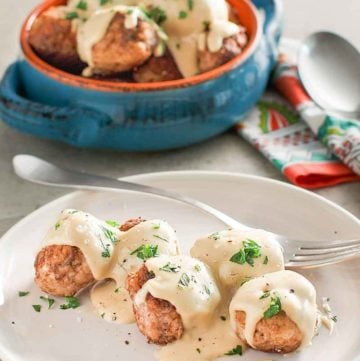 homemade Swedish meatballs and gravy on a plate and in a bowl
