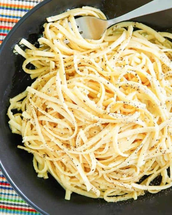 overhead view of a bowl of pasta with egg and parmesan cheese