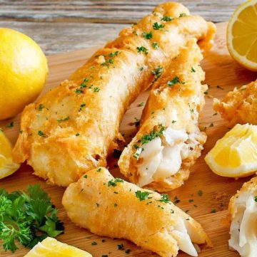 Homemade Captain D's batter dipped fish and lemons on a wood platter
