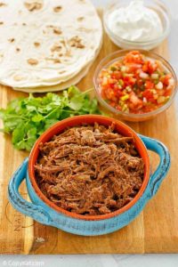 beef barbacoa, cilantro, salsa, tortillas, and sour cream