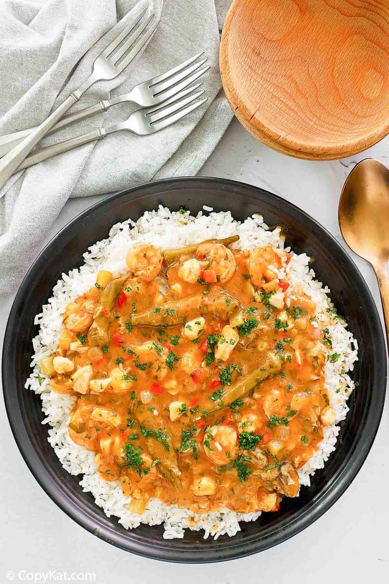 overhead view of seafood gumbo over rice in a black bowl