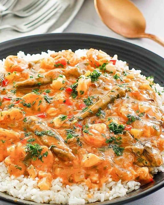 seafood gumbo over rice in a black bowl