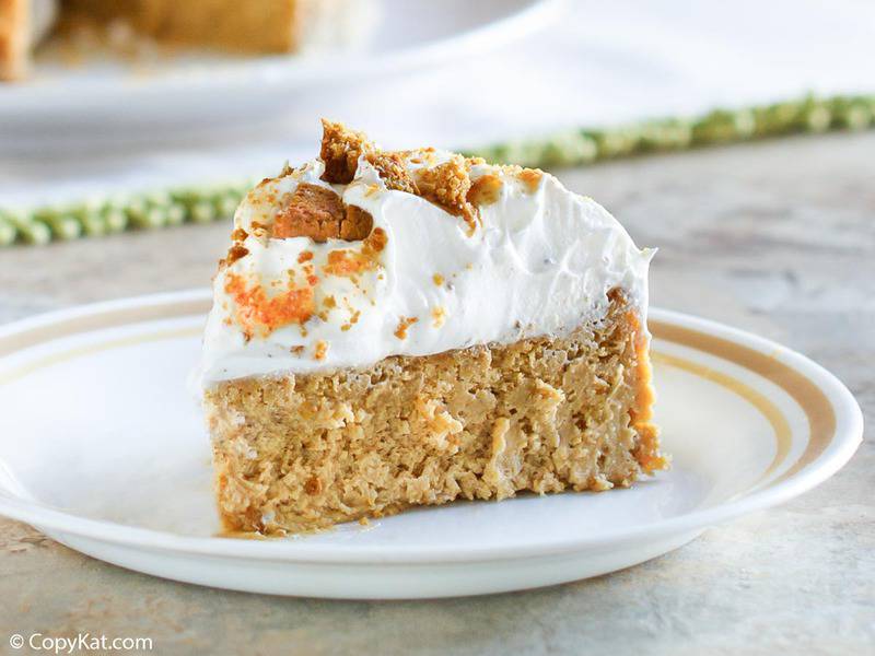 a slice of pumpkin cheesecake with gingersnap crust topped with whipped cream