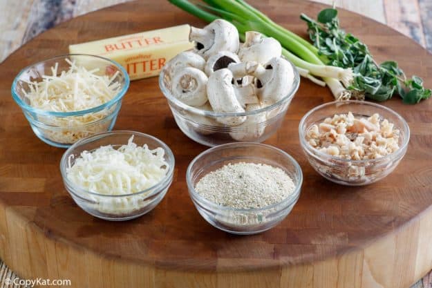 Olive Garden stuffed mushrooms ingredients on a round wood board