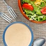 overhead view of a bowl of Russian dressing and a salad