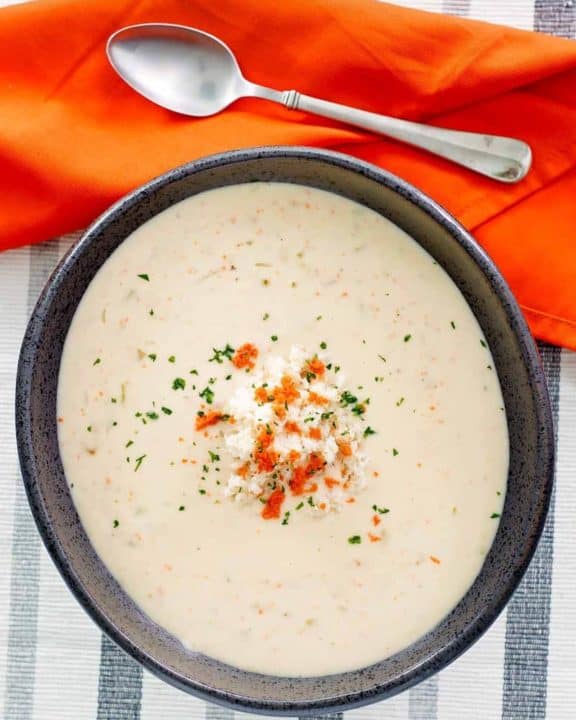 overhead view of a bowl of she crab soup, a napkin, and spoon