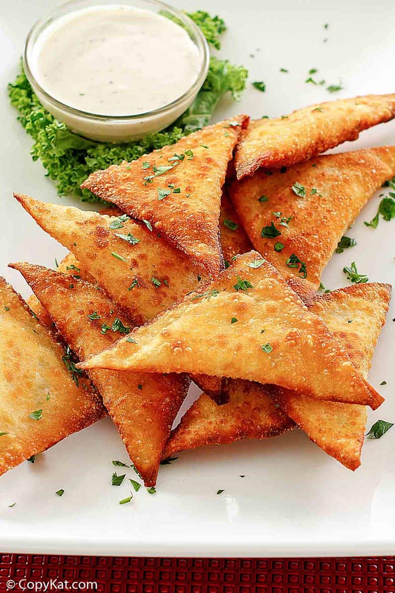 a platter of wonton jalapeno poppers with dipping sauce