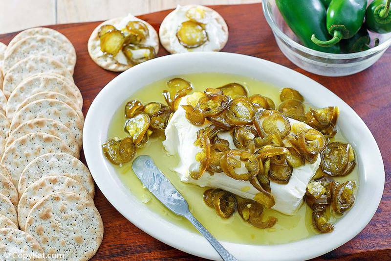 candied jalapenos over cream cheese next to crackers