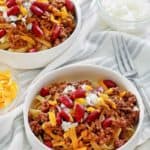 bowls of Cincinnati chili topped with cheese, onions, and kidney beans