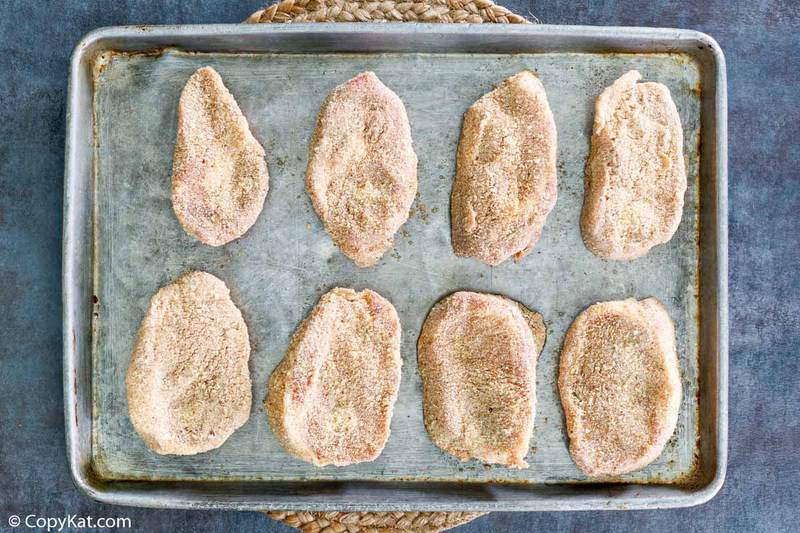 Homemade Shake and Bake pork chops on a baking sheet before baking