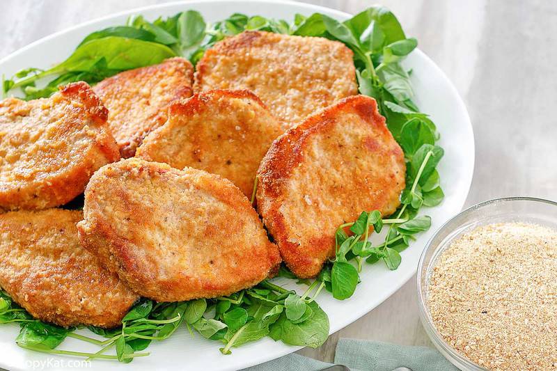 homemade Shake and Bake pork chops on a platter and a bowl of breading mix