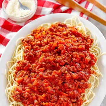 homemade Olive Garden Beef Bolognese over pasta on a platter