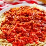 homemade Olive Garden Beef Bolognese sauce over pasta on a platter