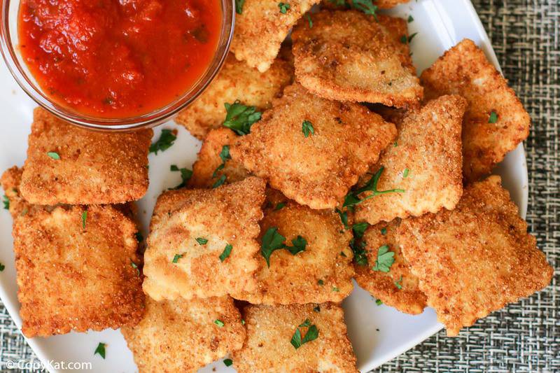 homemade Olive Garden toasted ravioli and a small bowl of marinara sauce