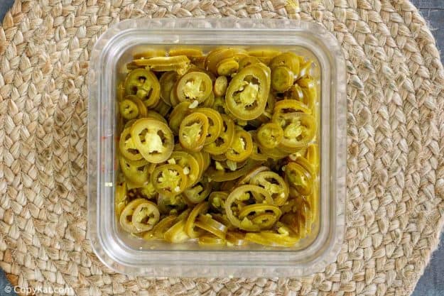 pickled jalapenos in a plastic container