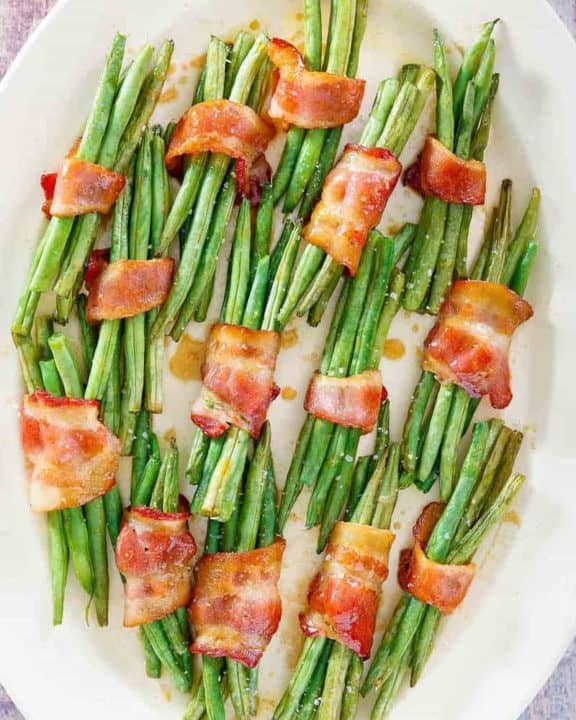 overhead view of bacon wrapped green bean bundles on a platter