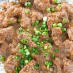 Overhead view of beef tips and gravy over rice on a plate