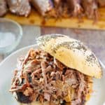a brisket sandwich in front of brisket slices