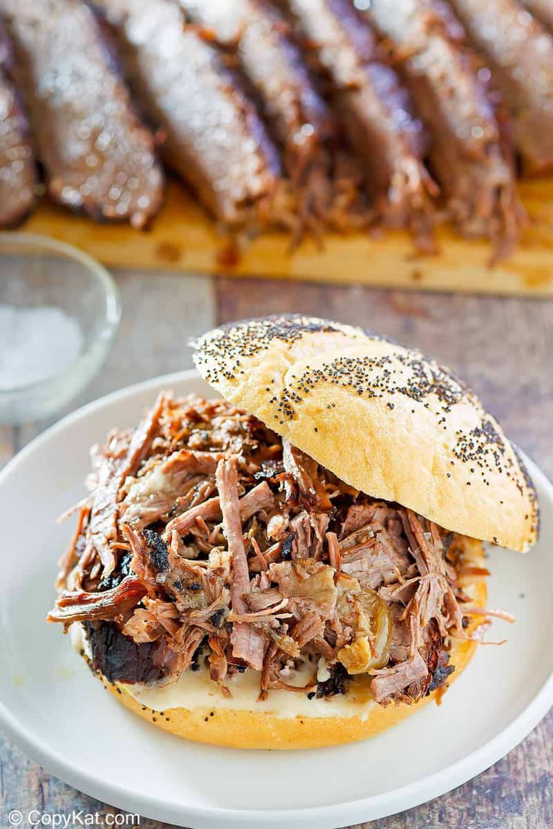 a brisket sandwich in front of brisket slices