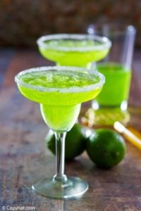 two homemade Red Lobster Dew Garita cocktails and limes