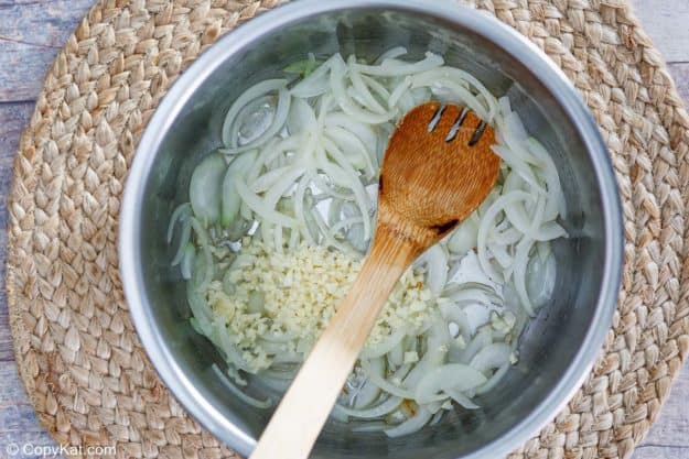 sliced onions and chopped garlic in an Instant Pot bowl