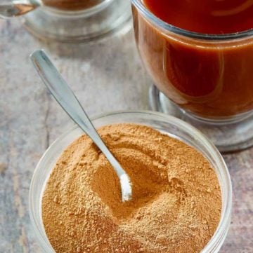 homemade Swiss Miss hot cocoa mix in a bowl next to mugs of hot cocoa