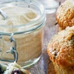 a jar of homemade vanilla sugar next to blueberry muffins