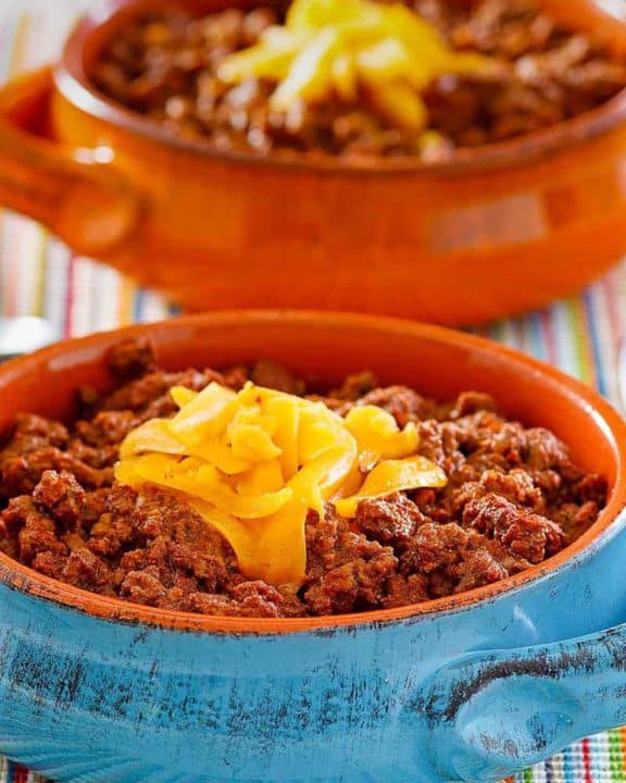bowls of homemade Wick Fowler 2 Alarm Chili topped with cheese