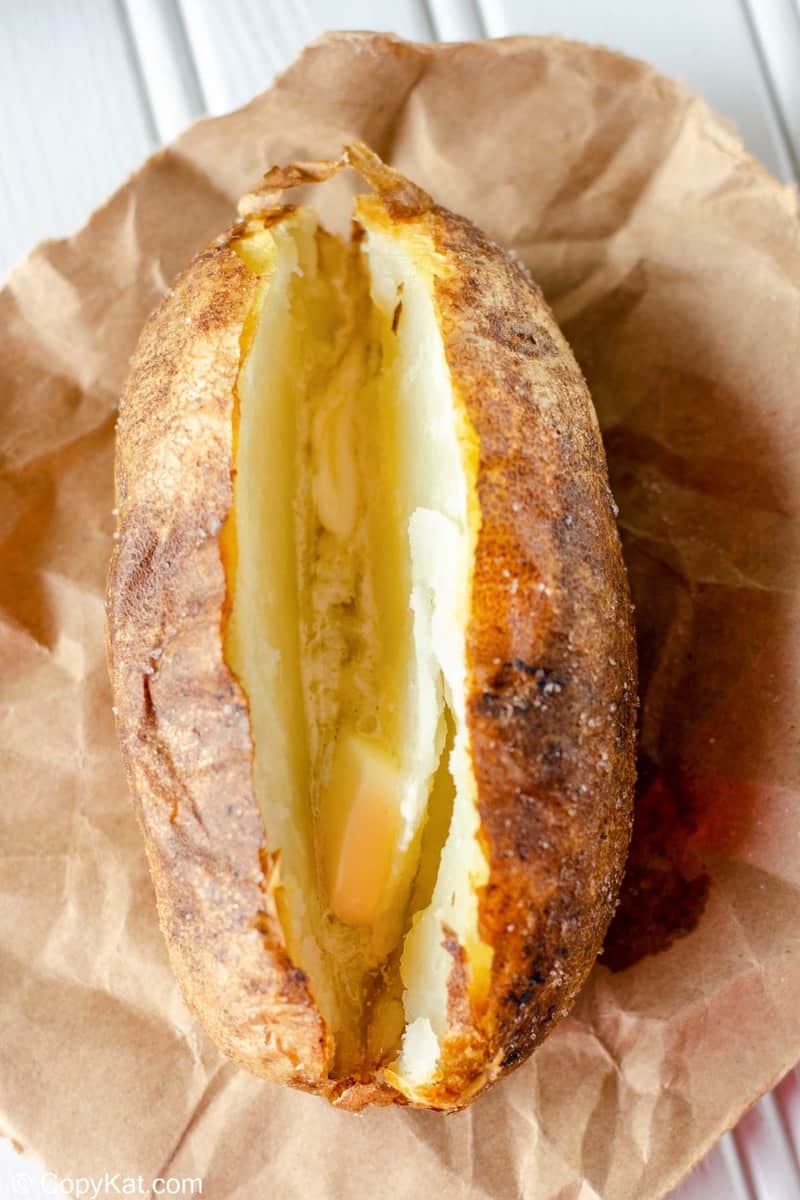 air fryer baked potato with butter on parchment paper