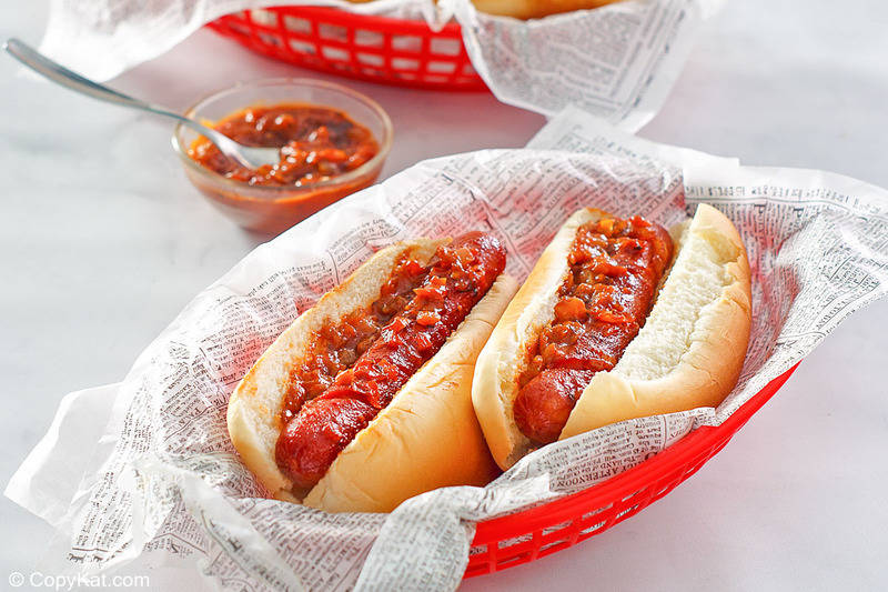 two baked hot dogs topped with homemade barbecue sauce in a serving basket