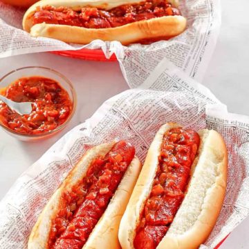 two baskets with baked hot dogs topped with barbecue sauce