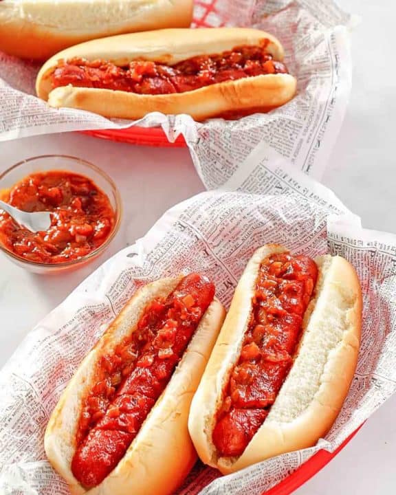 two baskets with baked hot dogs topped with barbecue sauce
