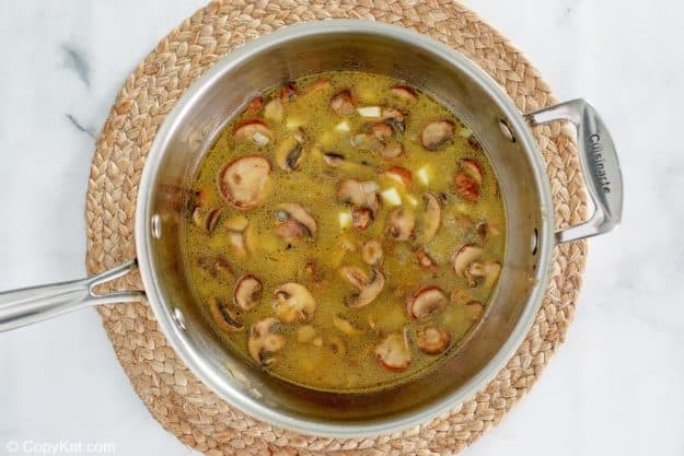 sauteed mushrooms, onions, and chicken broth in a saucepan