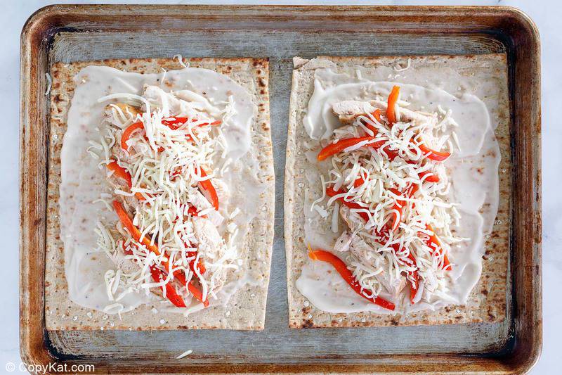 Homemade Olive Garden grilled chicken flatbread on a baking sheet before cooking in the oven