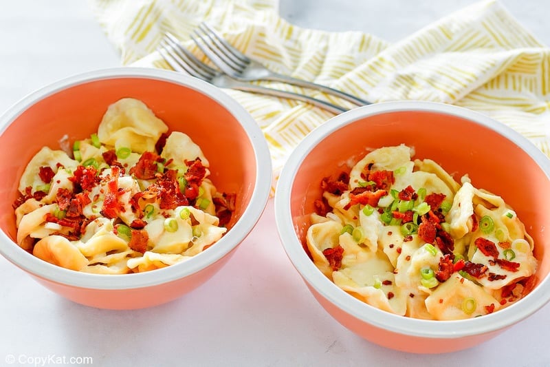 two forks, a napkin, and two bowls of homemade Olive Garden tortellini al forno
