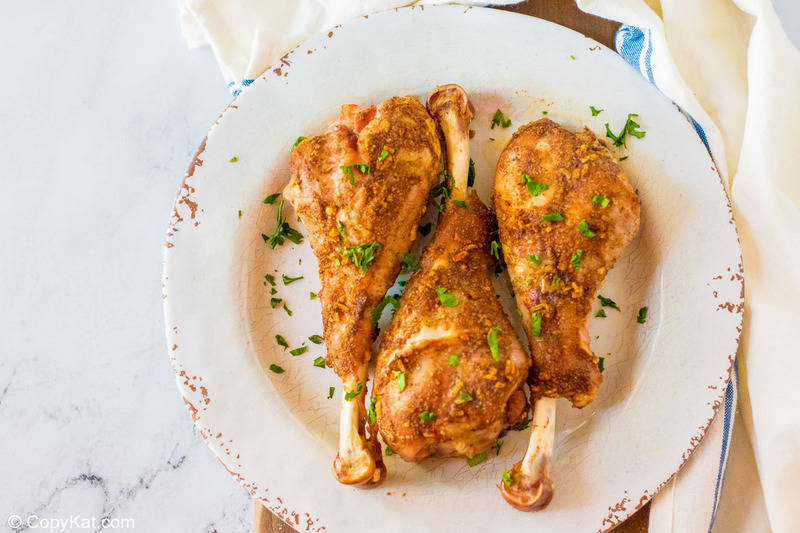 oven roasted turkey legs on a plate and a kitchen towel on a marble surface
