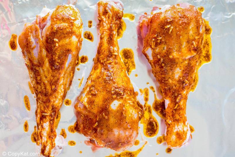 seasoned turkey legs on a foil-lined baking sheet