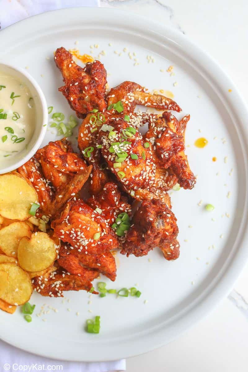 spicy chicken wings and potato chips on a plate