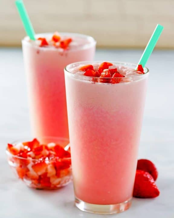 homemade Starbucks pink drink in two glasses and fresh strawberries