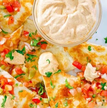 a bowl of homemade Taco Bell quesadilla sauce and quesadillas on a plate