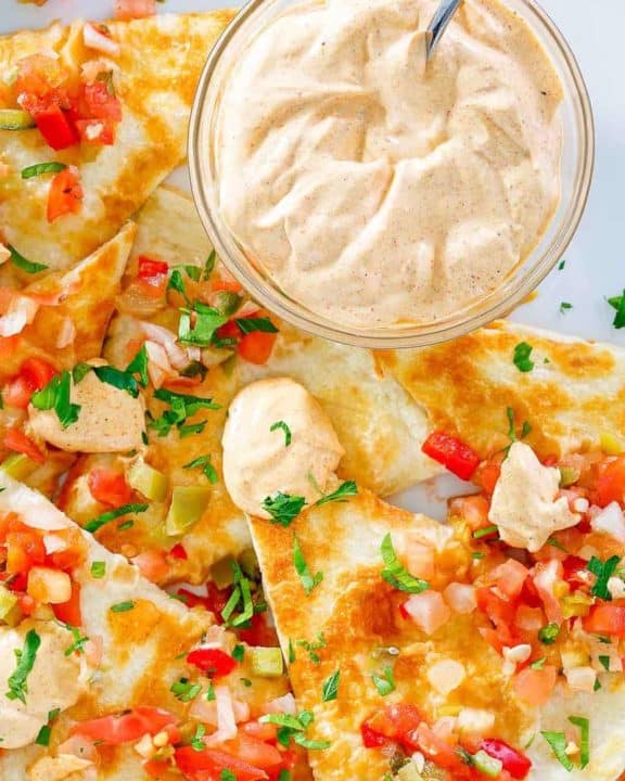 a bowl of homemade Taco Bell quesadilla sauce and quesadillas on a plate