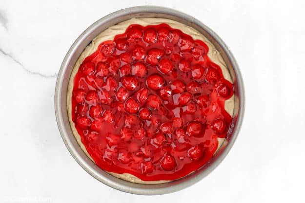 cherry coffee cake in a springform pan before being baked