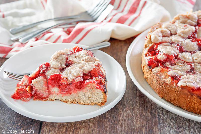 cherry coffee cake slice on a plate next to the cake