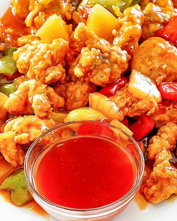 sweet and sour chicken and a bowl of homemade sweet and sour sauce