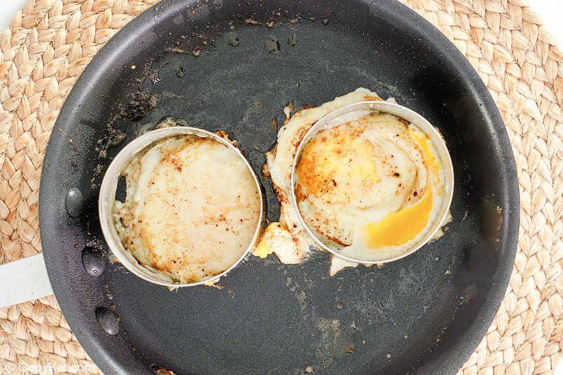 two fried eggs in rings in a skillet