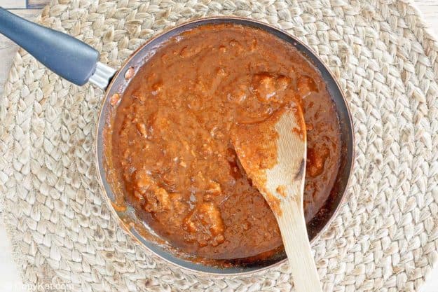 Hormel chili and a wooden spoon in a skillet