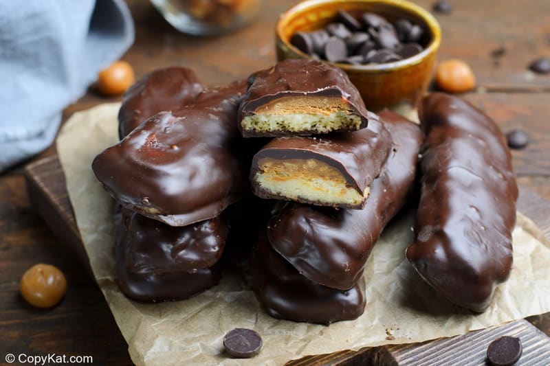 a pile of homemade Twix bars and a bowl of chocolate chips