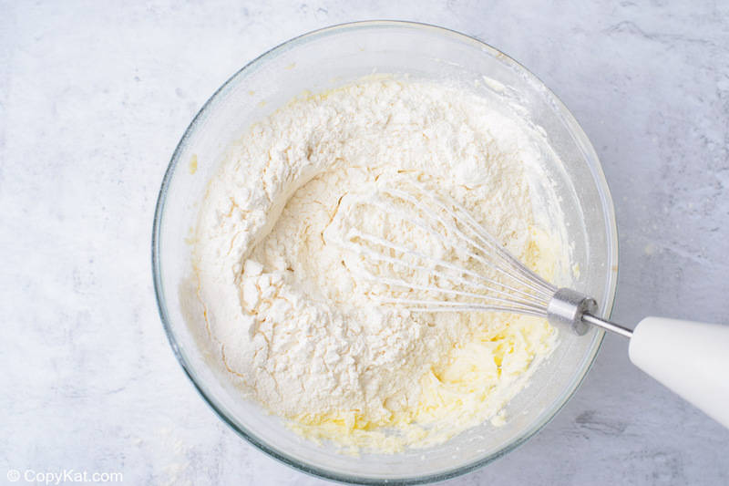 creamed butter and sugar with flour on top in a mixing bowl